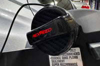 Rexpeed Dry Carbon Fuel Cap Cover for 2015-2021 VA Subaru WRX and 2022+ VB Subaru WRX (G72) installed on fuel filler cap, hanging on fuel door